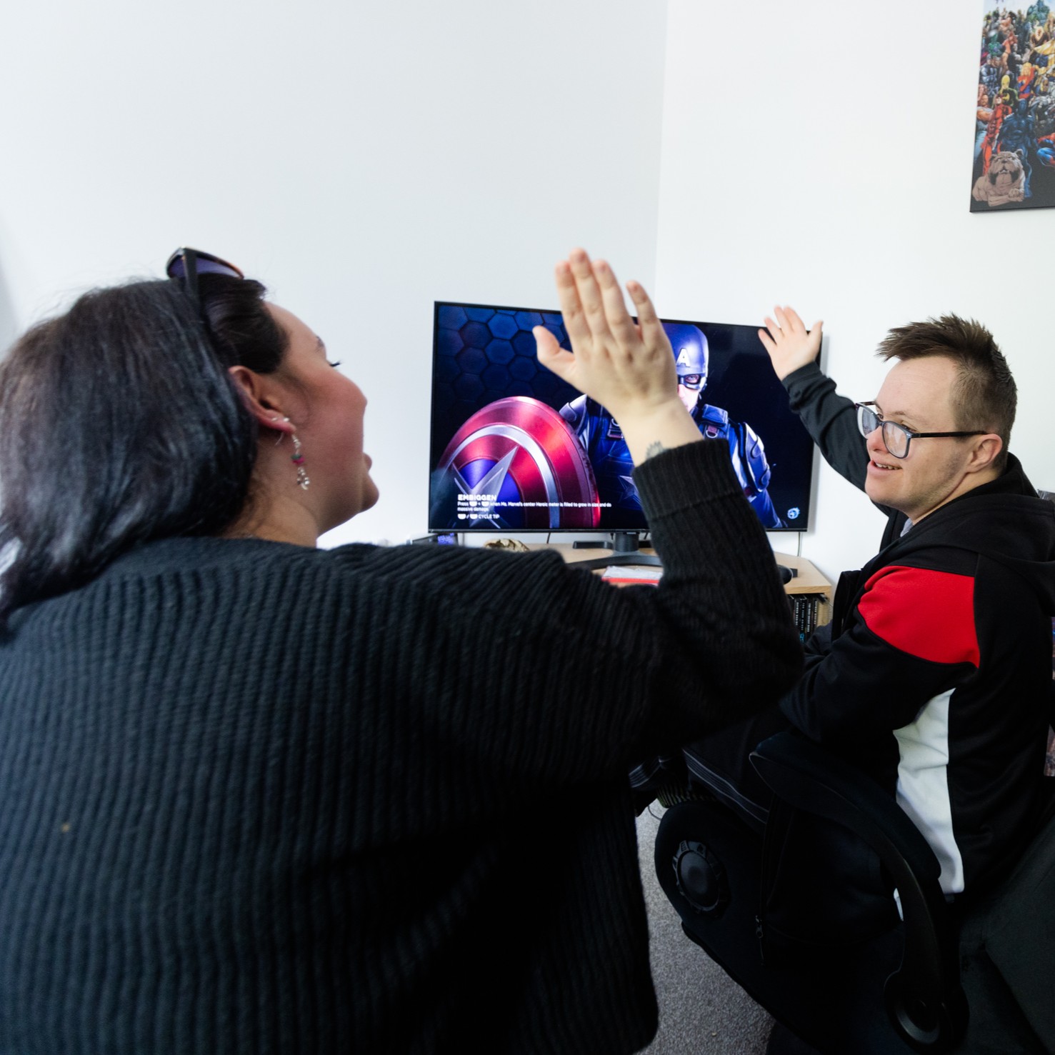 A support worker with their client in front of a screen