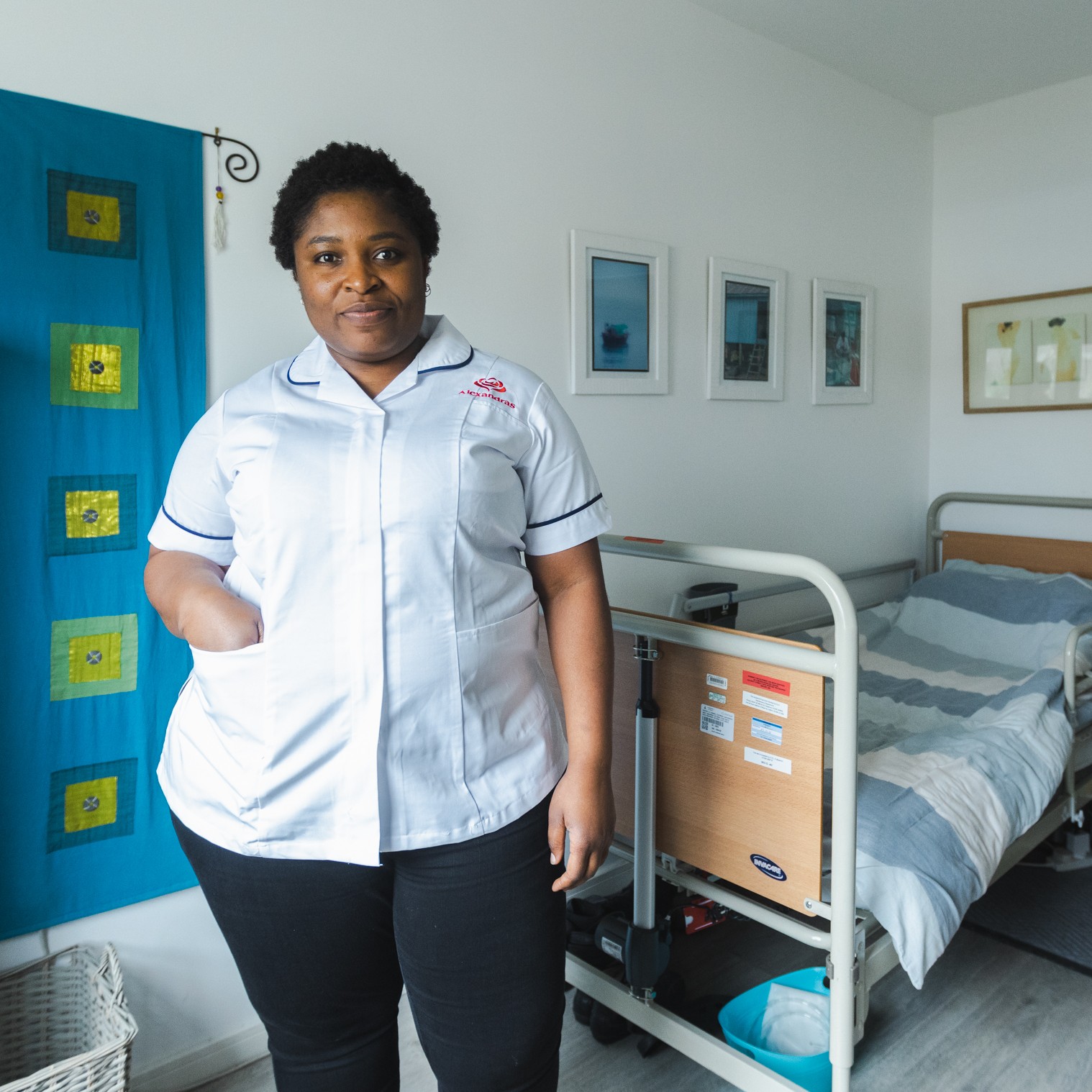 A female care worker next to a bed in a room
