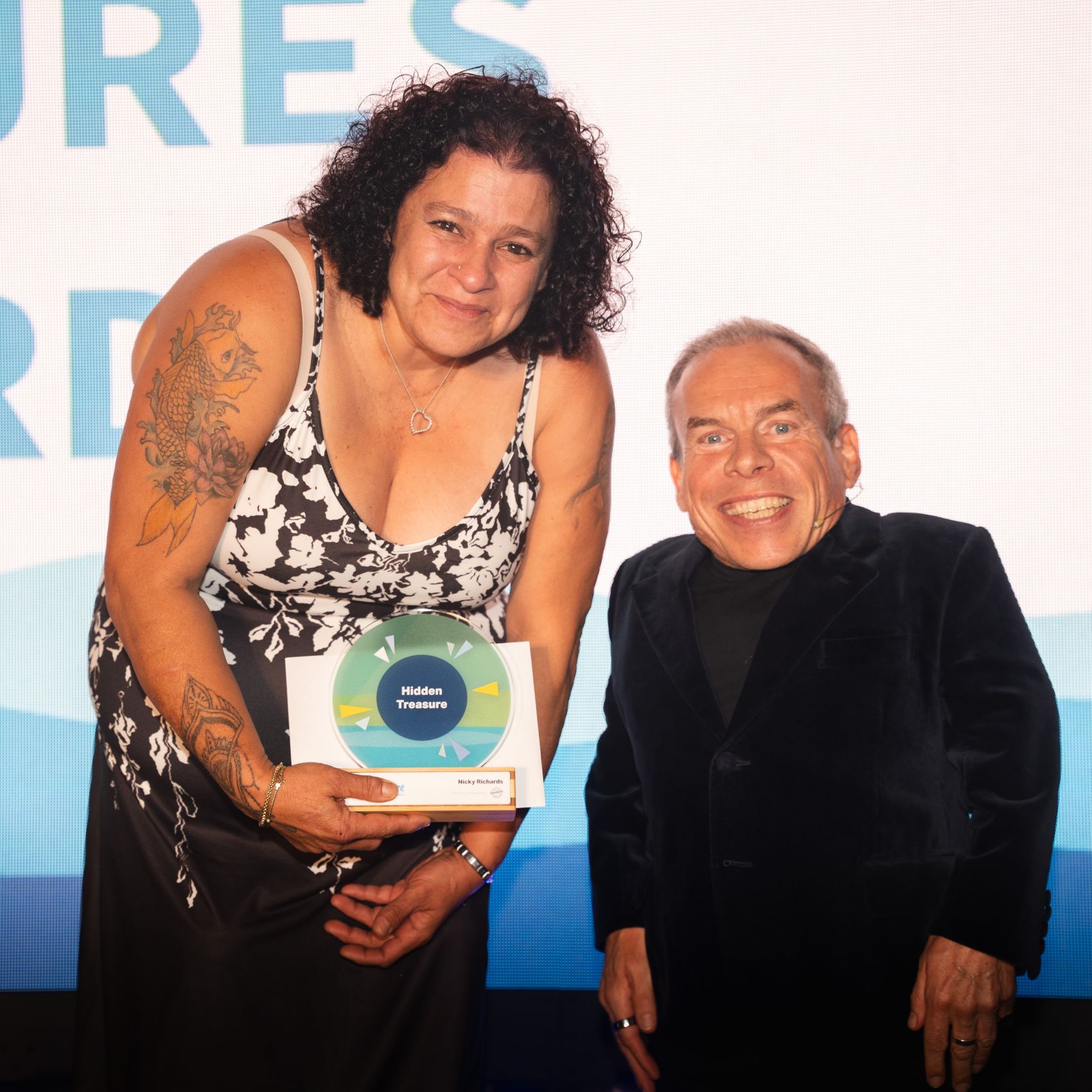 A woman with a care award from actor Warwick Davis