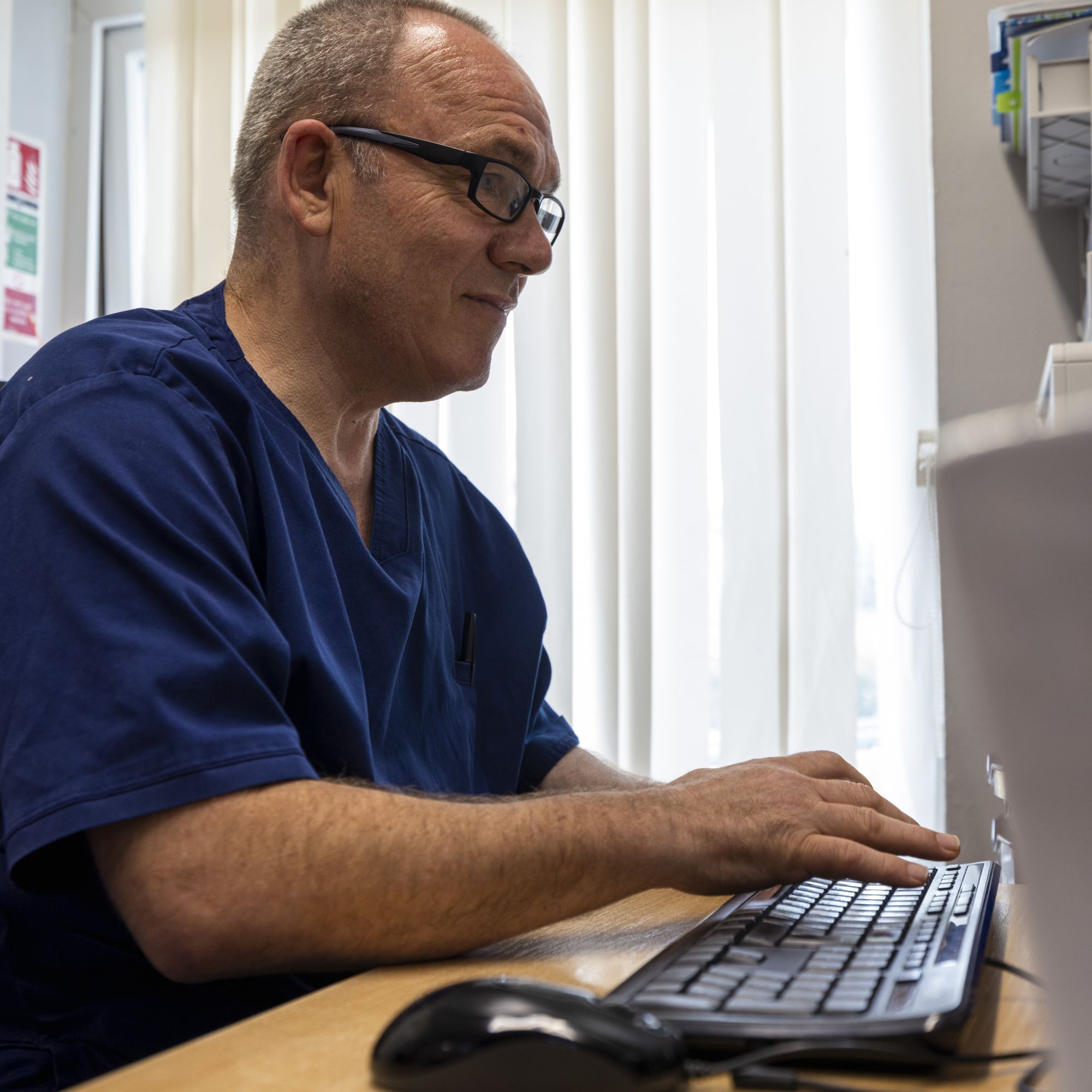 A man typing into a computer keyboard