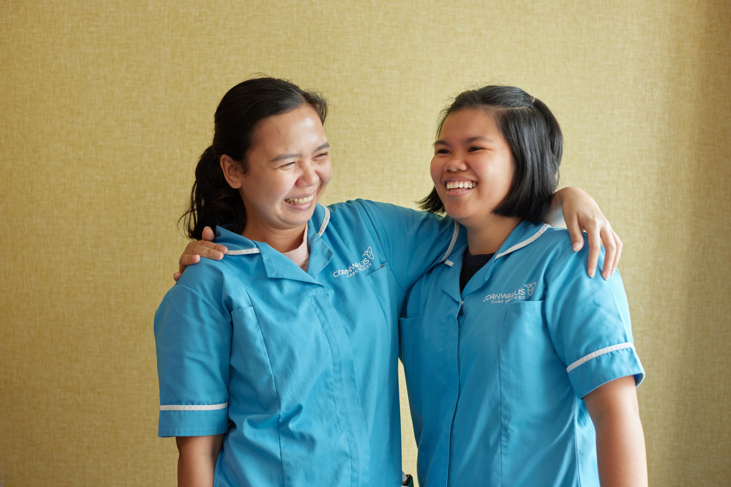 Two female care professionals embracing