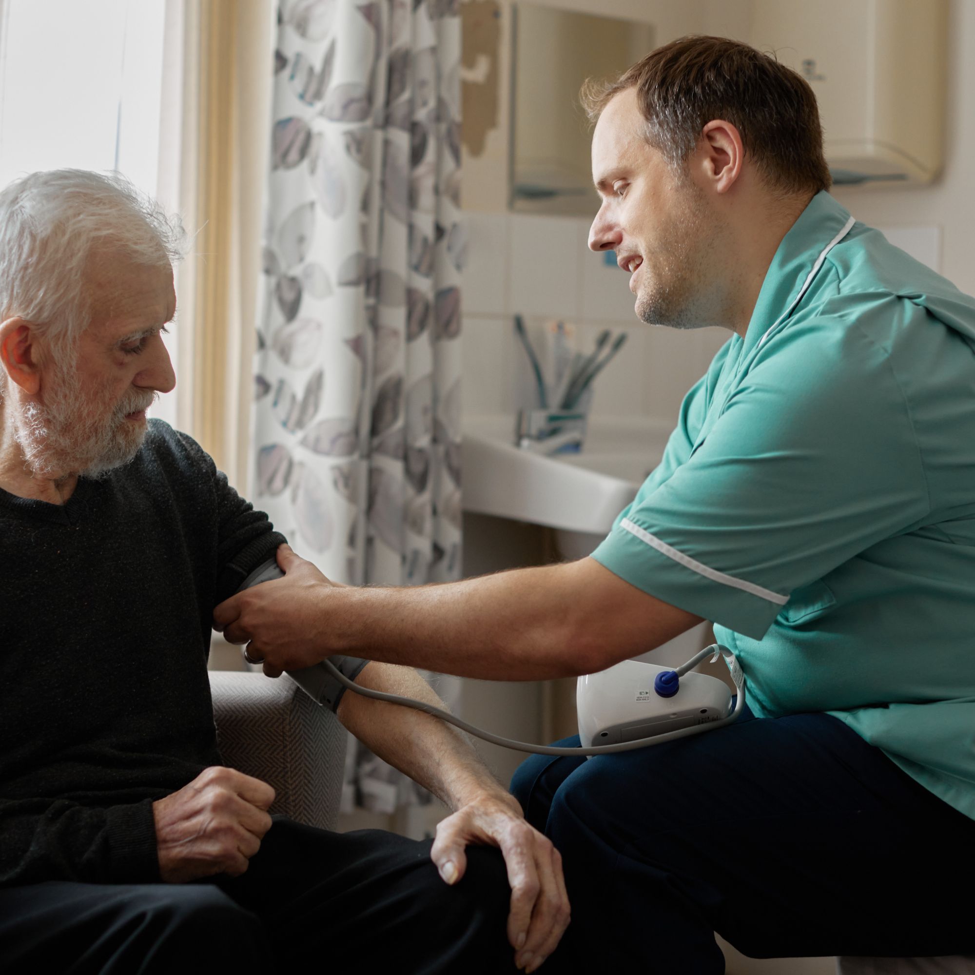 A man checking someones blood pressure